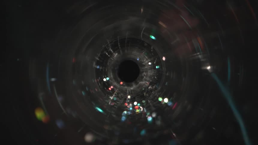 Colored light points reflected inside a cylinder or lens seen in closeup