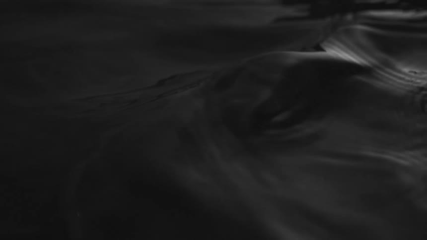 Dark liquid forming a small rise with ripples around it