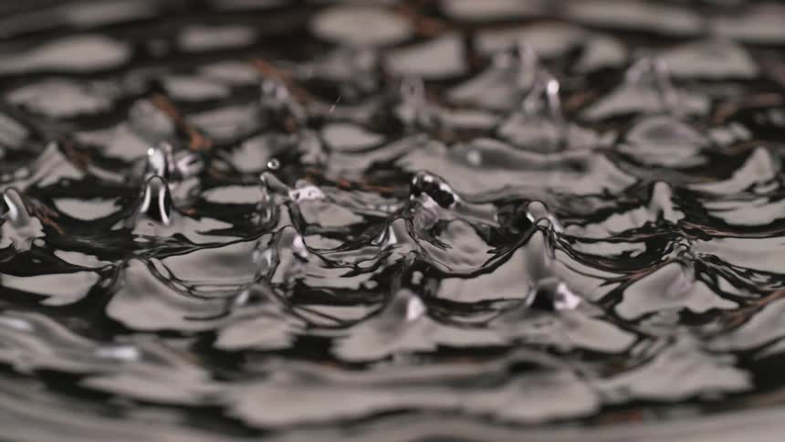 Clear liquid forming multiple columns and raised splashes after strong impact