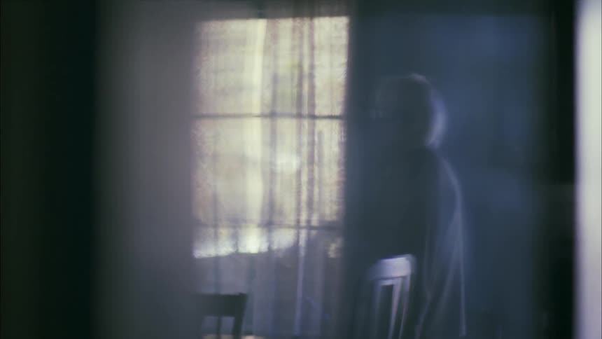 An older woman pacing in a room in a house