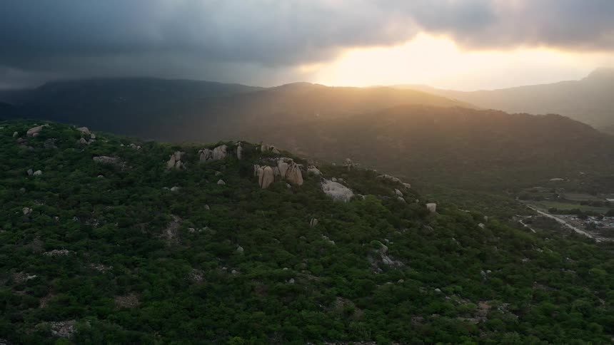 The sun shines through the clouds on the landscape