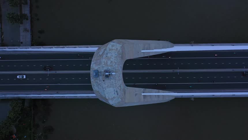 Modern bridge seen from above with multiple traffic lanes over a dark river