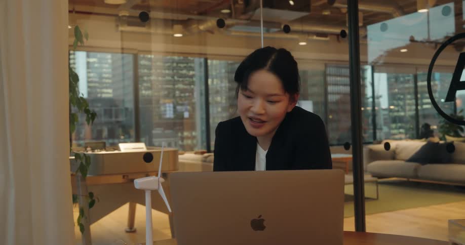The woman is talking with someone on her laptop