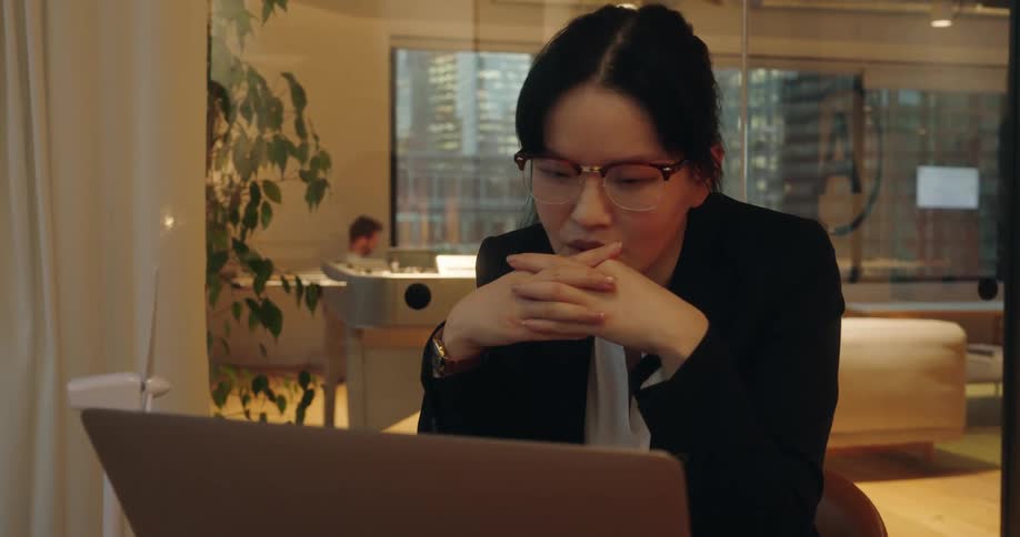 Woman in a suit takes part in a meeting on the laptop