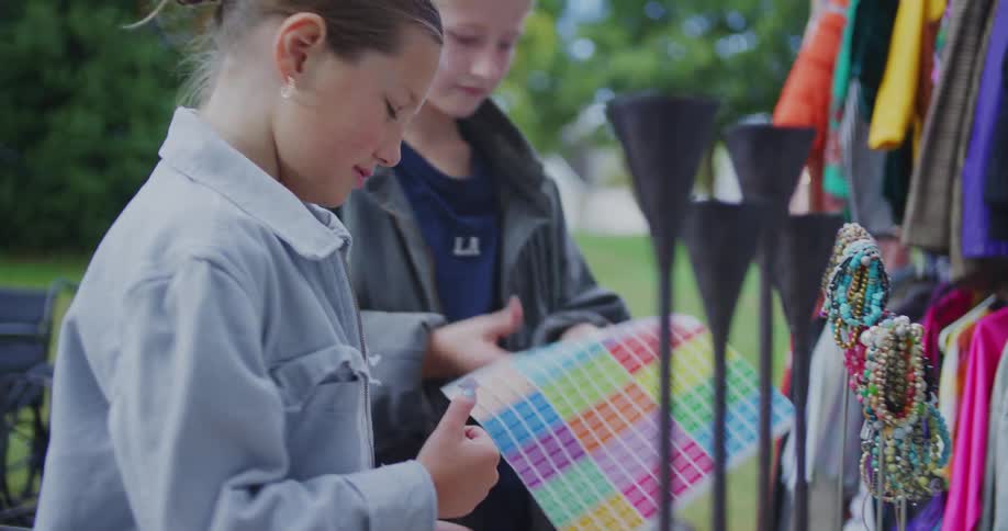 Two girls putting price tags on items at a yard sale
