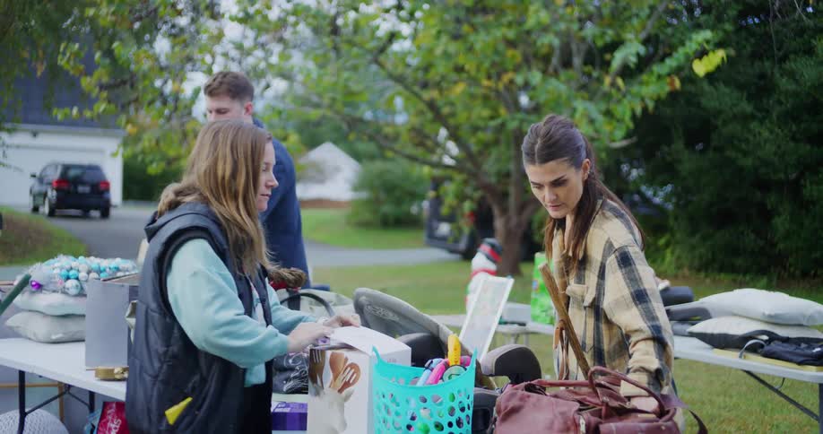People are talking and looking through items at a yard sale