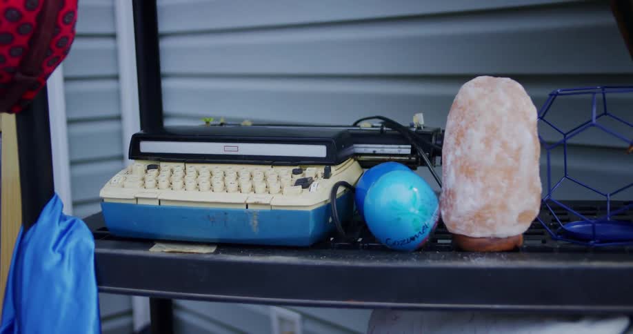 Old typewriter blue ball and salt lamp arranged on a shelf
