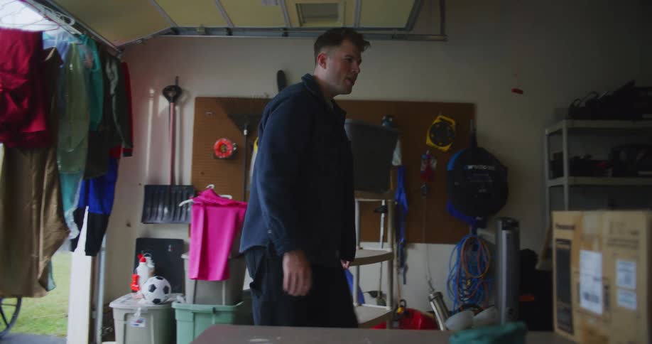 Man carries a large cardboard box out of the garage
