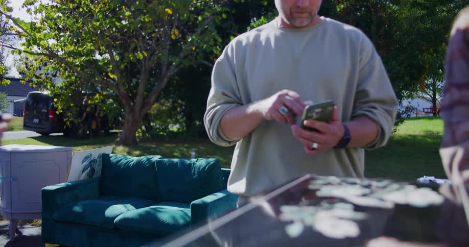 Two people buying items at a yard sale