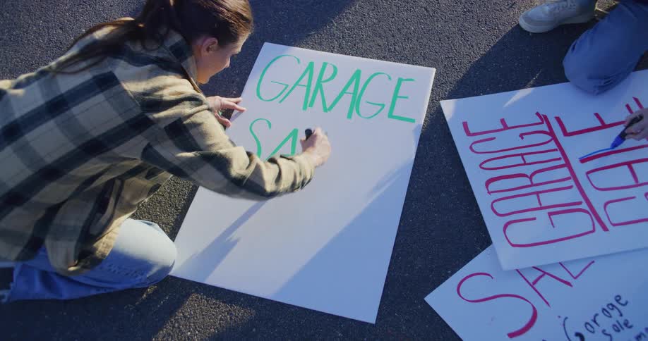 A woman is writing with a green pen on a white board that is on the ground