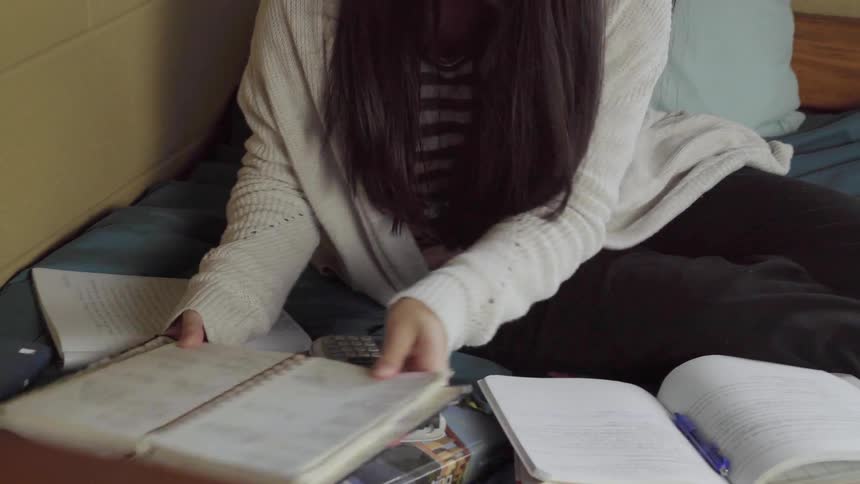 A teenager is doing homeworker in her room