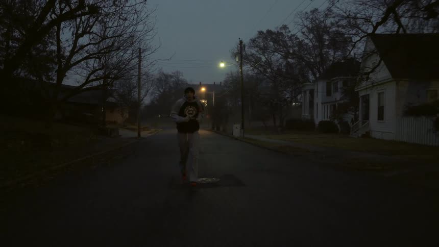 A jogger runs on a residential street at night