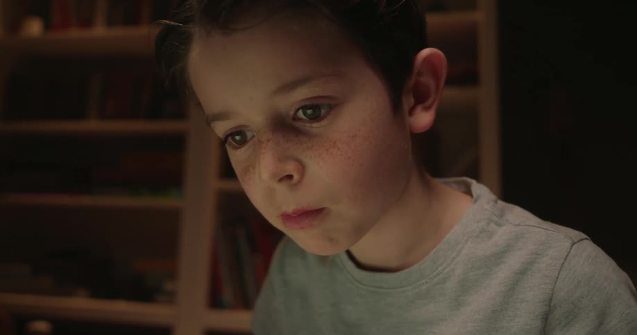 The boy is examining something at home
