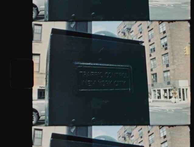 Metal box with the inscription new york city appears in the foreground in front of urban buildings