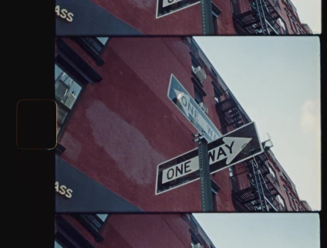A one way sign is in front of the building