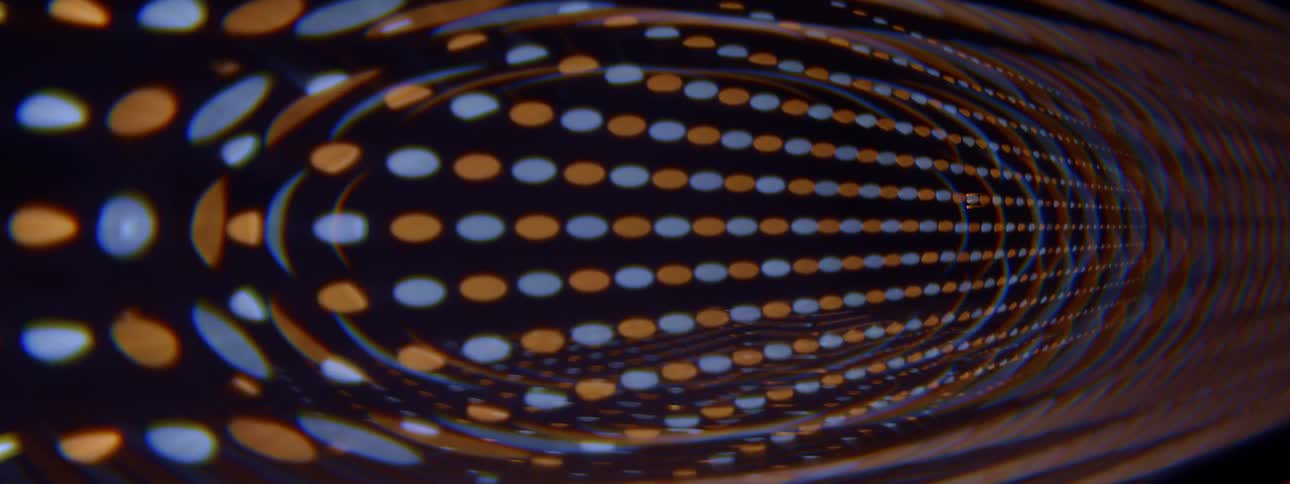 Red and blue objects move across the wall in a warping manner