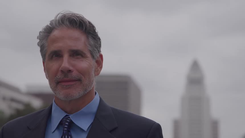 The man is smiling on a cloudy day