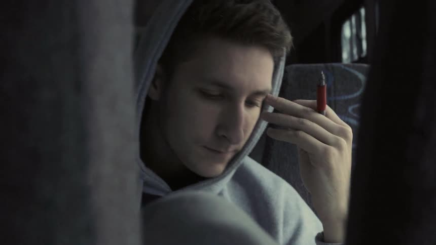 A man is holding a pen in a bus