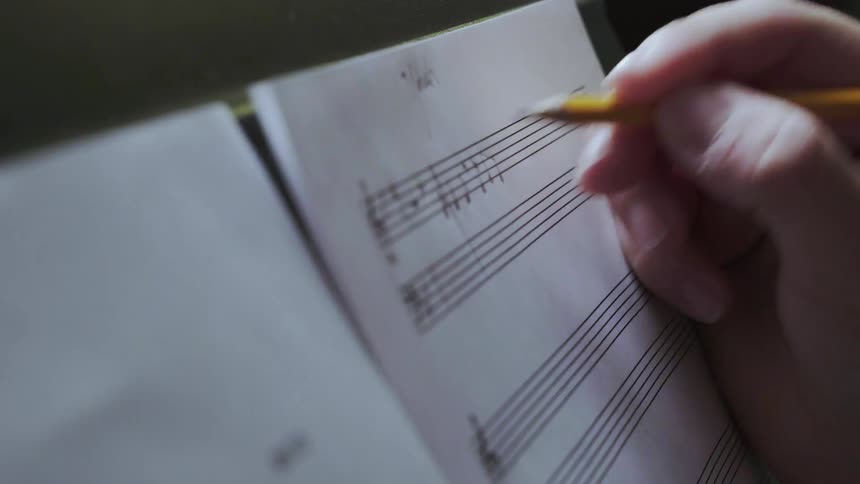 A person writes some music in a book