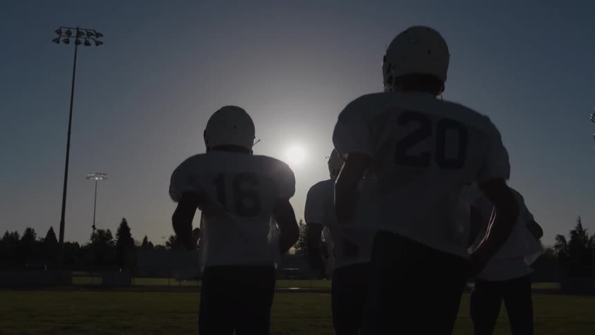 Team of football players run on to the field