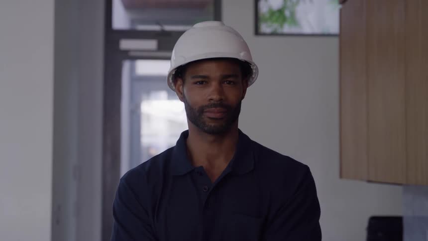 Man wearing a safety helmet stands in an indoor setting