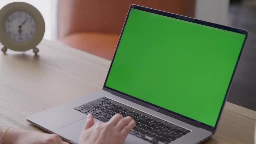 A woman swipes the touch pad of a laptop computer using her finger