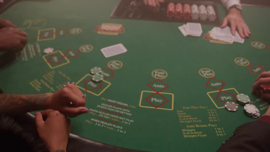 A dealer distributes cards to players placing bets at a green casino table