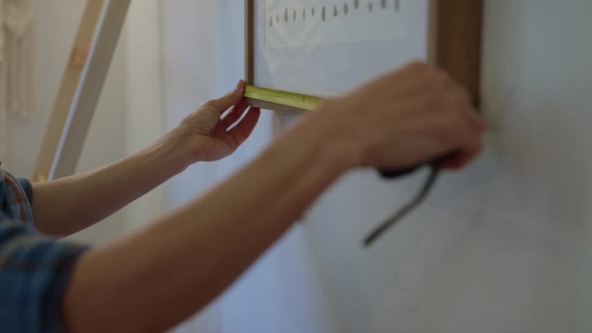 A person measuring a painting