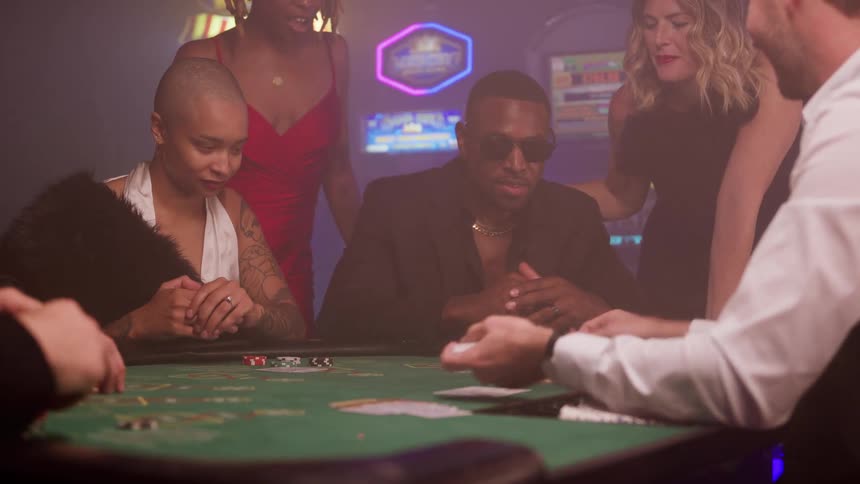 People play poker in casino with slot machines in background