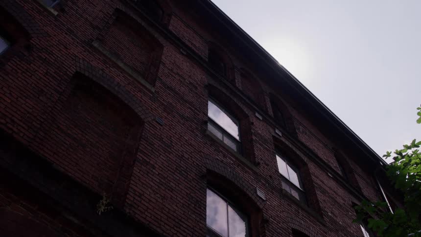 Brick building with arched windows lit by afternoon sun