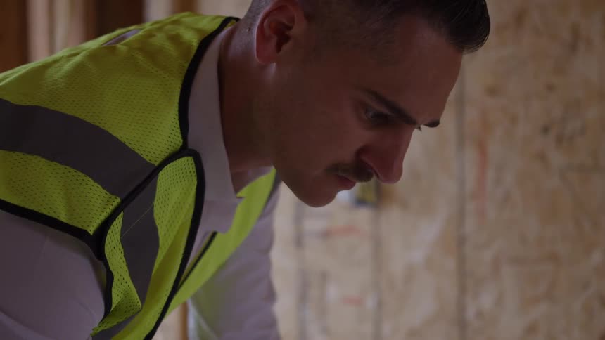 Close up of a young male construction worker working in a building under construction during daytime