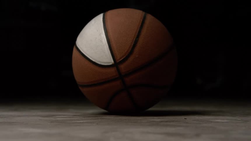 Light shines on a basketball spinning on the floor
