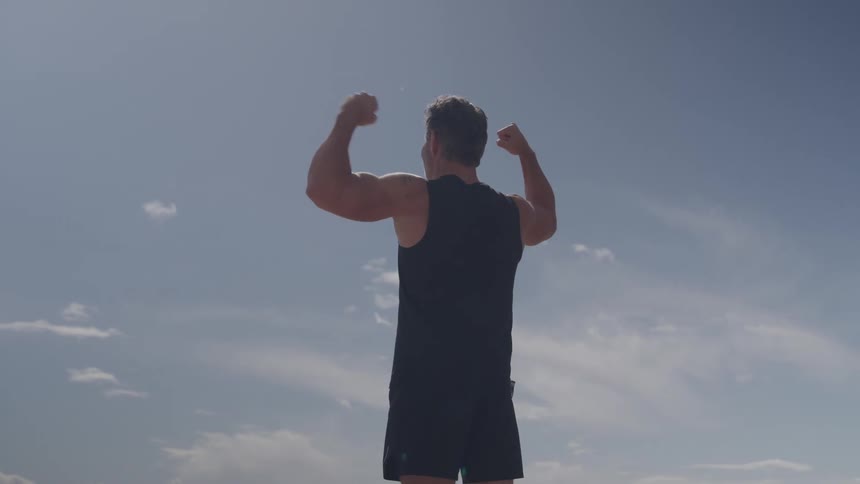 Man in sportswear flexing his arms to show his muscles