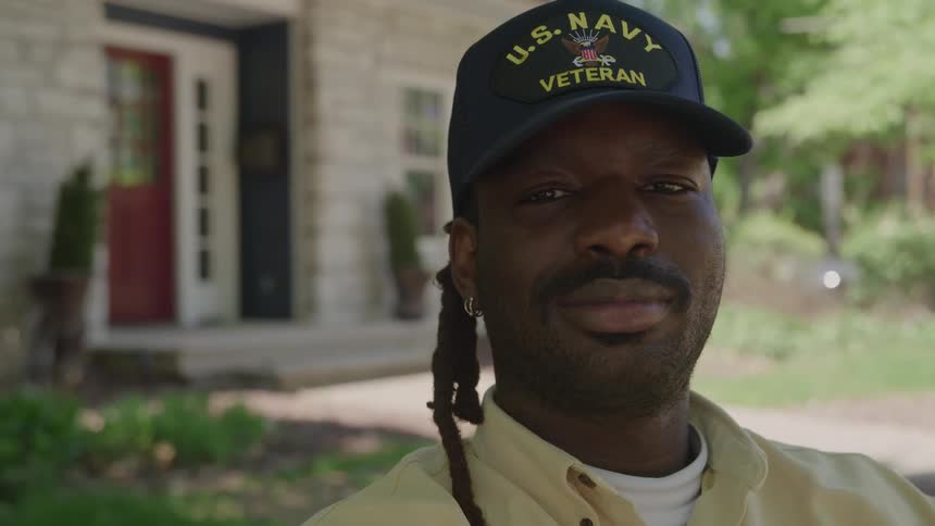 Close up portrait of a young black man sitting outdoors in a suburban city during daytime