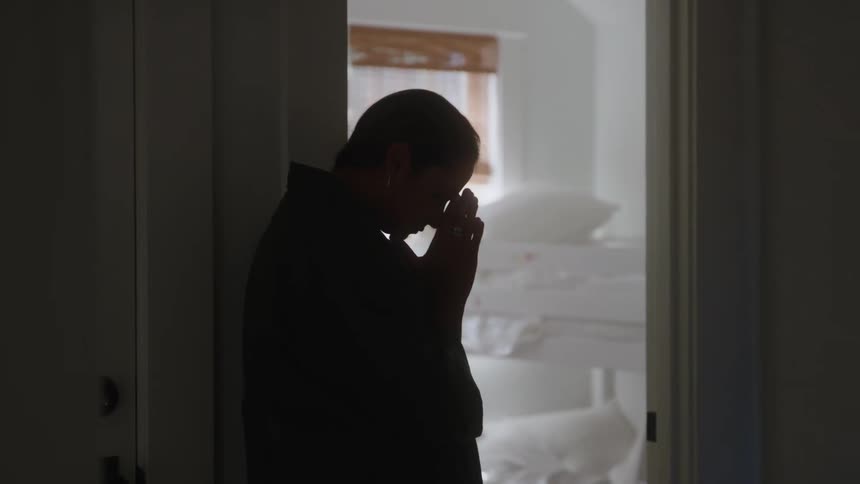 The woman is praying in the hallway