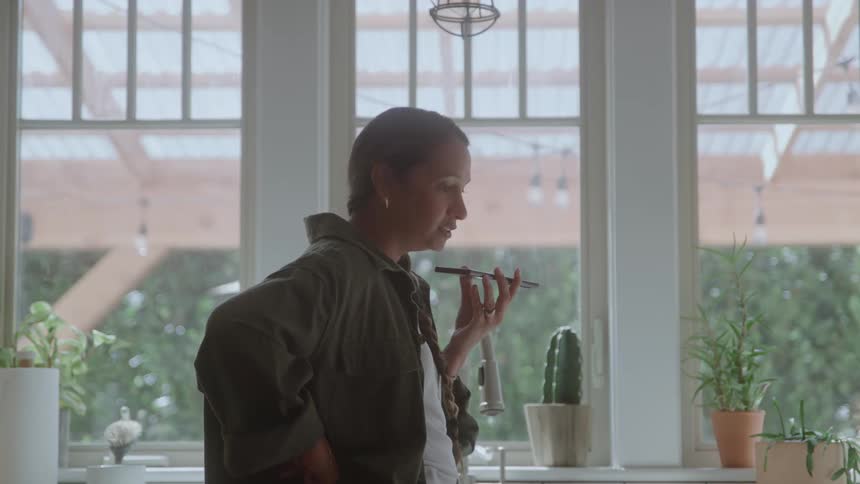 A woman talking on a phone in a room
