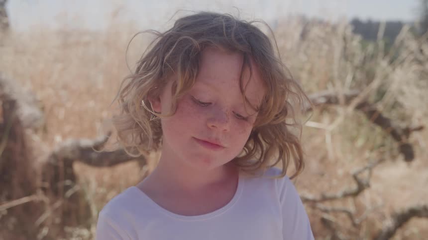 A portrait of a child standing outdoors