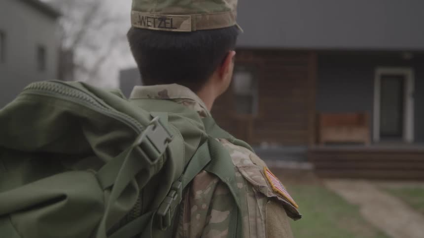 A man standing outdoors in an army outfit