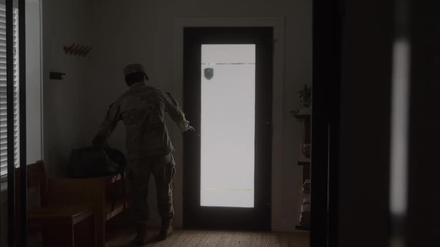 Soldier adjusts his beret and exits through the door