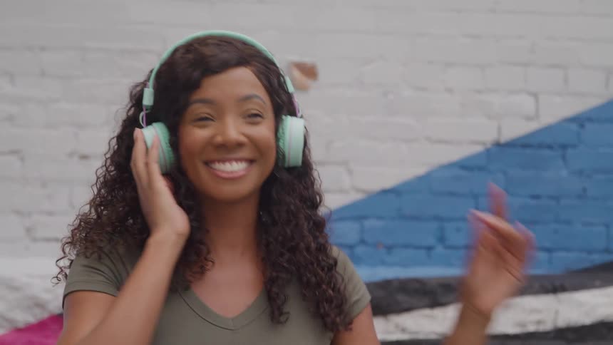 The woman is dancing while listening to music on her headphones