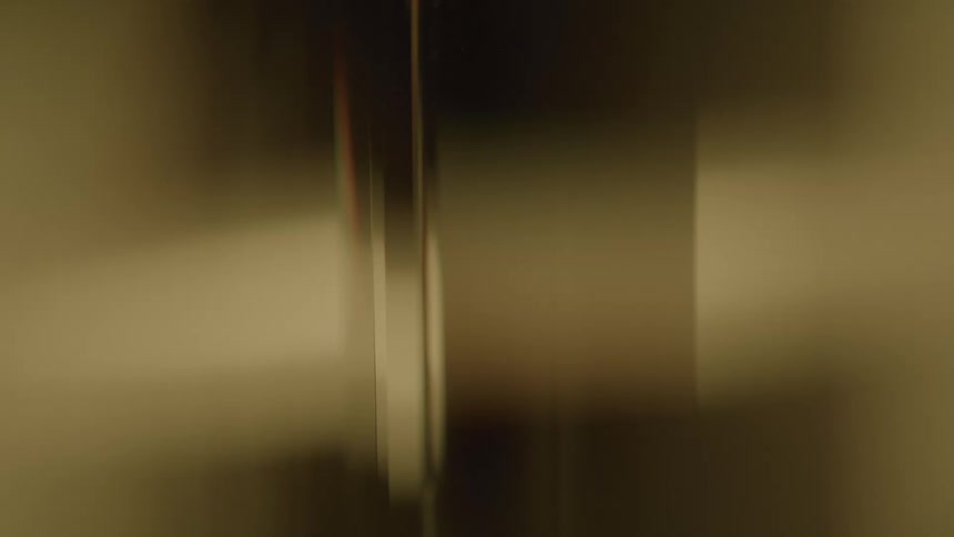 Closeup of vertical golden brown abstract shapes with blurred reflections