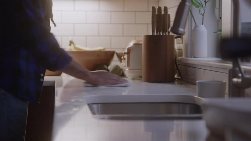 Persons hand wiping a kitchen countertop