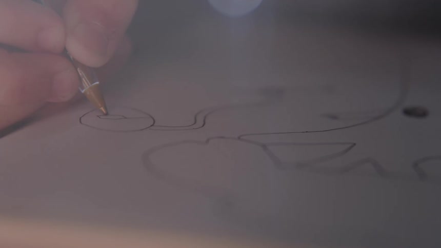 Hand drawing lines on paper with a pen