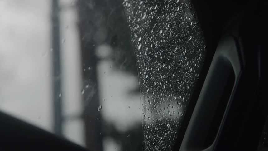 Raindrops scattered across a car window