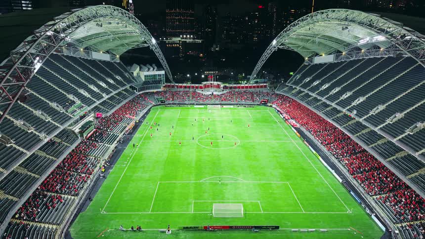 Sports fans watch a soccer game at night