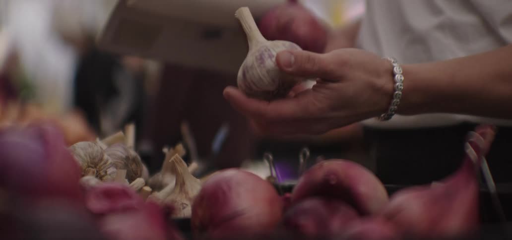 Man inspecting garlic at a farmers market