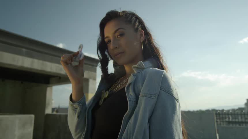 A woman models with a fidget spinner outside on a sunny day