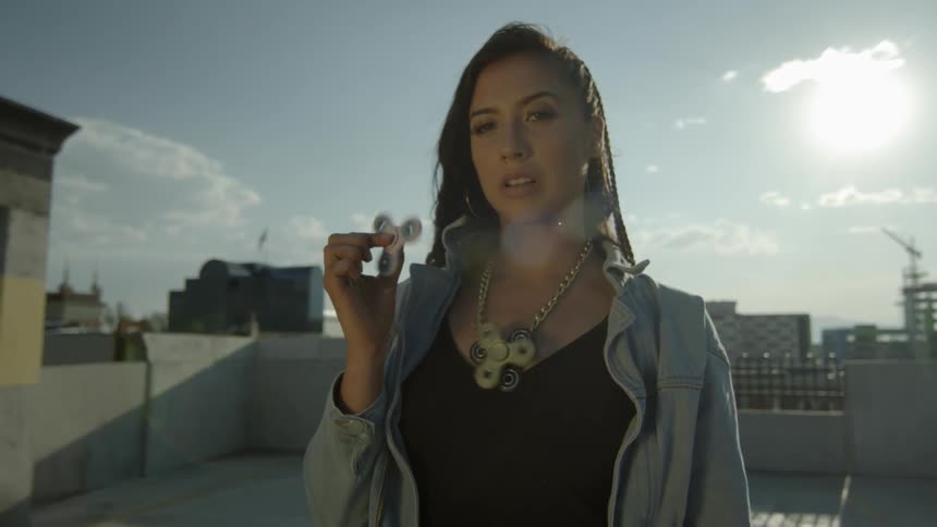 A woman stands on a rooftop with multiple fidget spinners