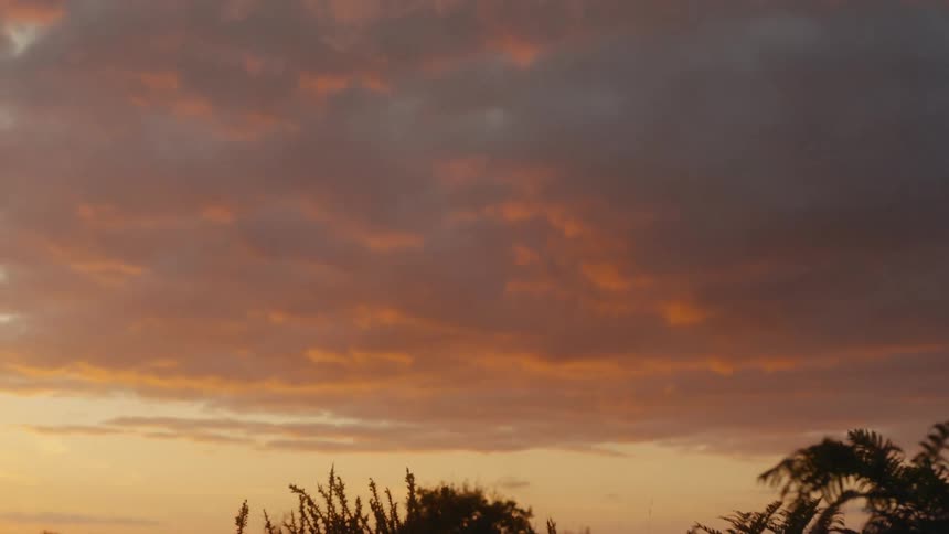 A landscape view of a highland beneath a cloudy sunset sky
