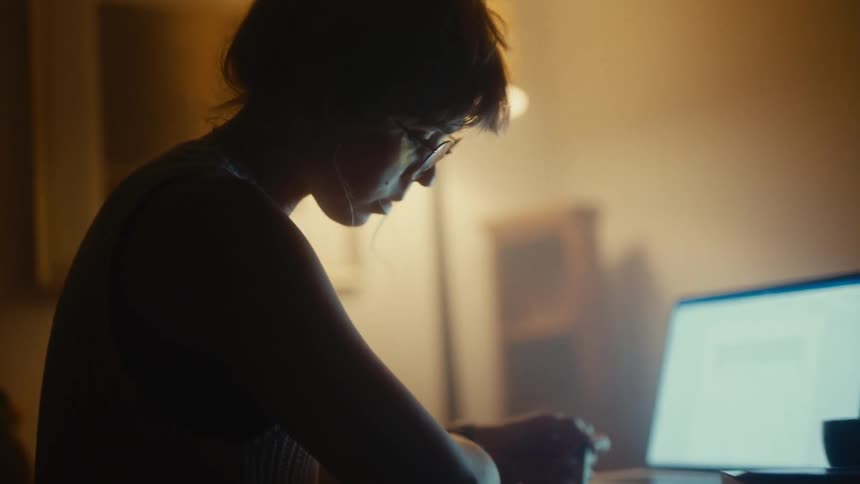 The woman reads her laptop and writes